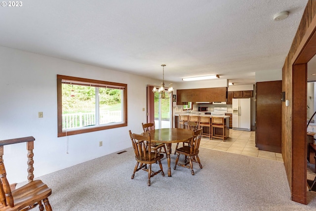 carpeted dining area featuring an inviting chandelier