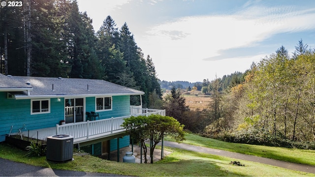 back of house featuring a lawn, a wooden deck, and cooling unit