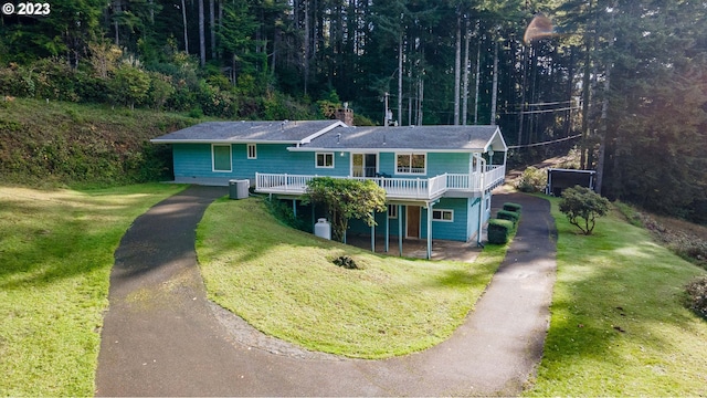 view of front of property featuring a wooden deck, cooling unit, and a front yard