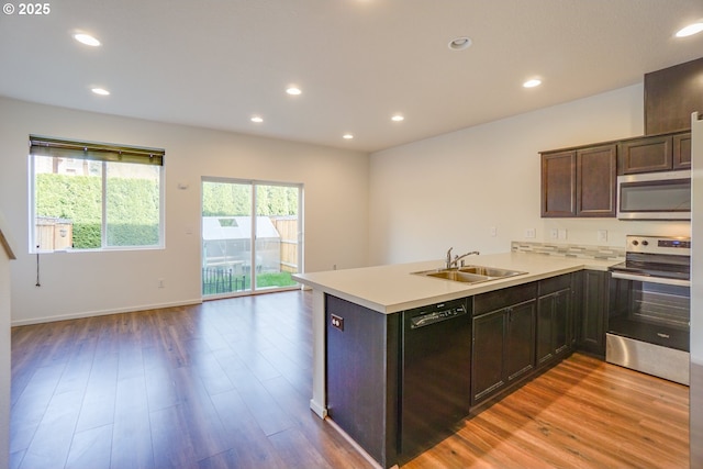 2153 NE 118th Pl, Vancouver, WA 98684 - kitchen featuring appliances with stainless steel finishes, a sink, light wood-style floors, a peninsula, and dark brown cabinets
