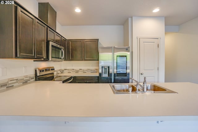 2153 NE 118th Pl, Vancouver, WA 98684 - kitchen featuring appliances with stainless steel finishes, a sink, dark brown cabinets, tasteful backsplash, and recessed lighting
