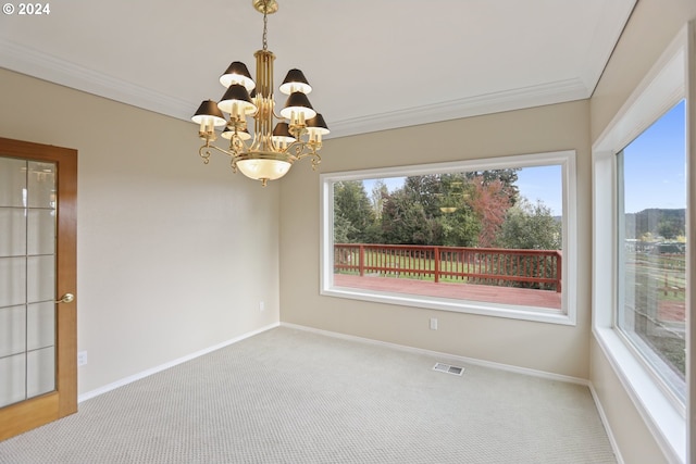 carpeted spare room with an inviting chandelier, crown molding, and plenty of natural light