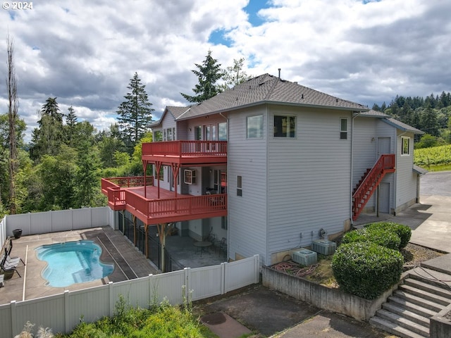 rear view of house with a pool side deck, a patio area, and central air condition unit