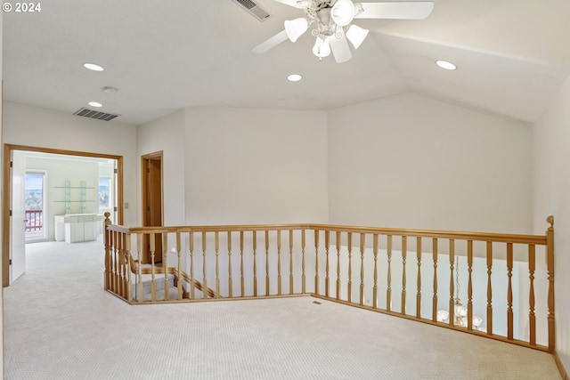 corridor featuring lofted ceiling and light carpet