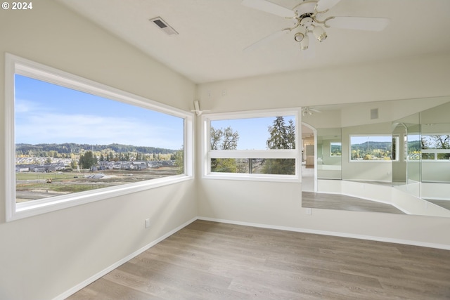 unfurnished sunroom featuring ceiling fan