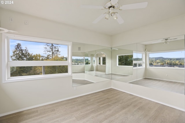 unfurnished sunroom featuring ceiling fan