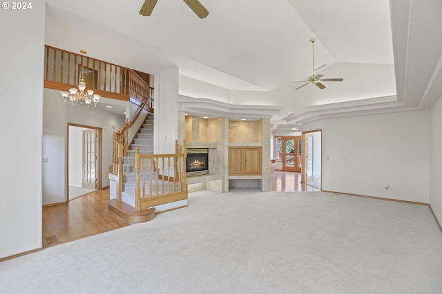 unfurnished living room featuring a tiled fireplace, french doors, and ceiling fan