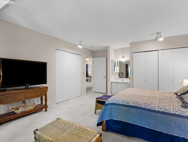 8512 SW Brightfield Cir, Tigard, OR 97223 - bedroom with light carpet, multiple closets, a sink, and ensuite bath