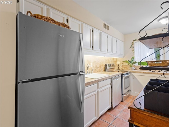 8512 SW Brightfield Cir, Tigard, OR 97223 - kitchen with appliances with stainless steel finishes, a sink, white cabinets, and light countertops