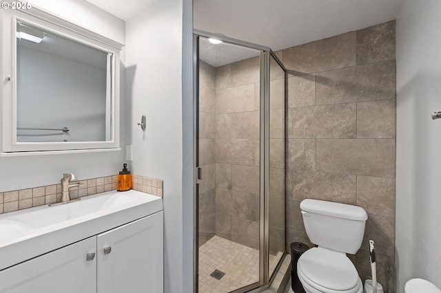 bathroom featuring vanity, a shower stall, and toilet