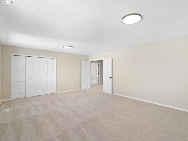 12576 NW Maplecrest Way, Banks, OR 97106 - unfurnished bedroom with light colored carpet, a closet, and a textured ceiling