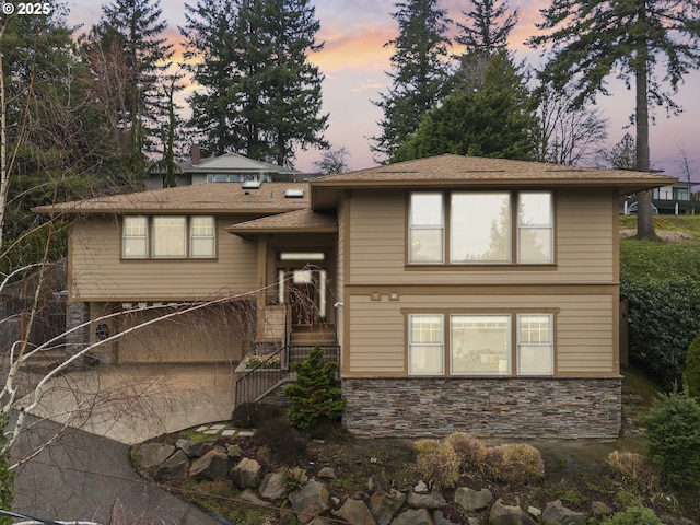 view of front facade with stone siding and driveway