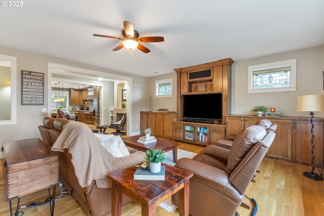 living room with a ceiling fan and light wood finished floors