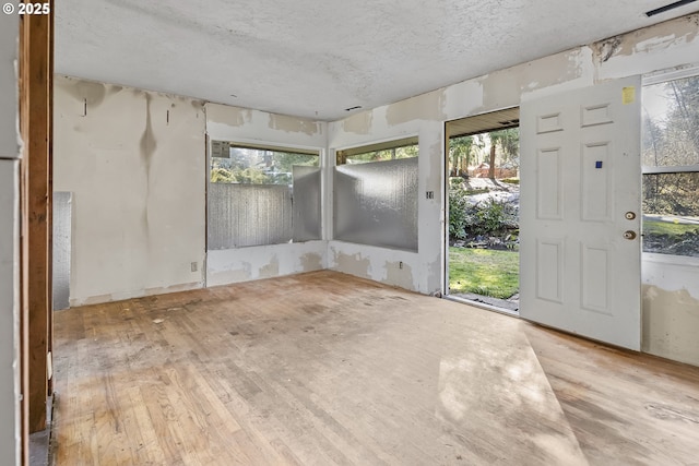 empty room featuring a textured ceiling and wood finished floors