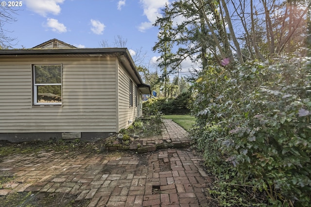 view of side of property with a patio and crawl space