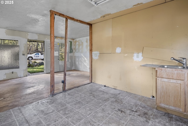 empty room with a textured ceiling and a sink