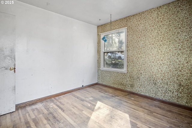 empty room featuring baseboards and wood finished floors