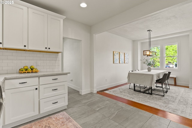 dining space with an inviting chandelier, baseboards, light tile patterned floors, and recessed lighting
