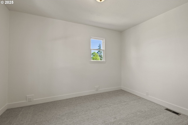 unfurnished room with baseboards, light carpet, and visible vents