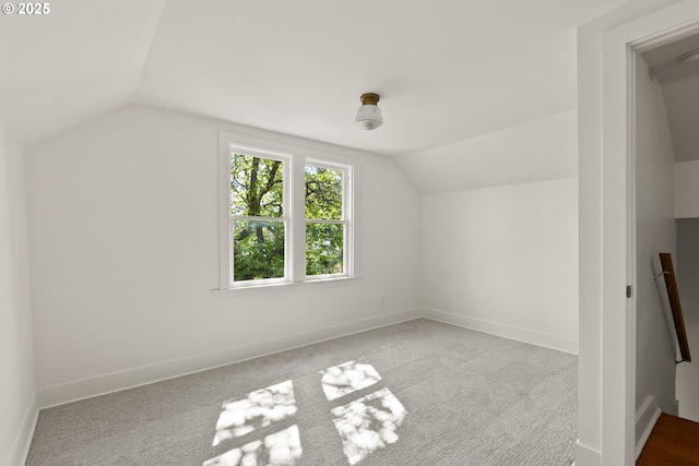 bonus room with baseboards, lofted ceiling, and carpet floors