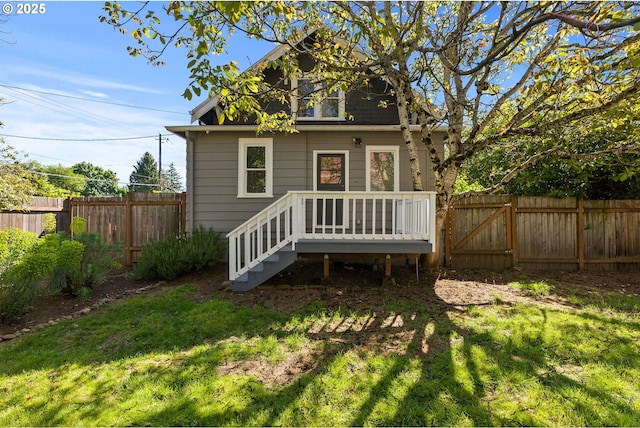 back of property with a fenced backyard and a yard