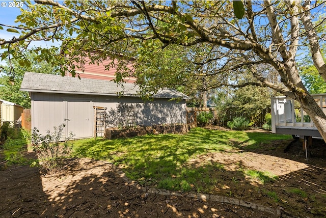 view of yard with a deck, an outbuilding, and fence