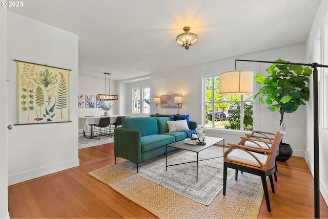 living room with a chandelier, wood finished floors, and baseboards