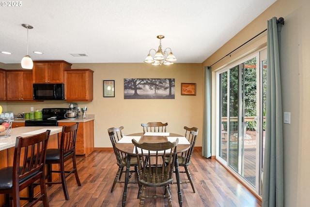 dining space with dark hardwood / wood-style flooring and an inviting chandelier