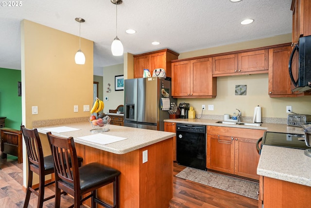 kitchen featuring black appliances, sink, hanging light fixtures, dark hardwood / wood-style flooring, and kitchen peninsula