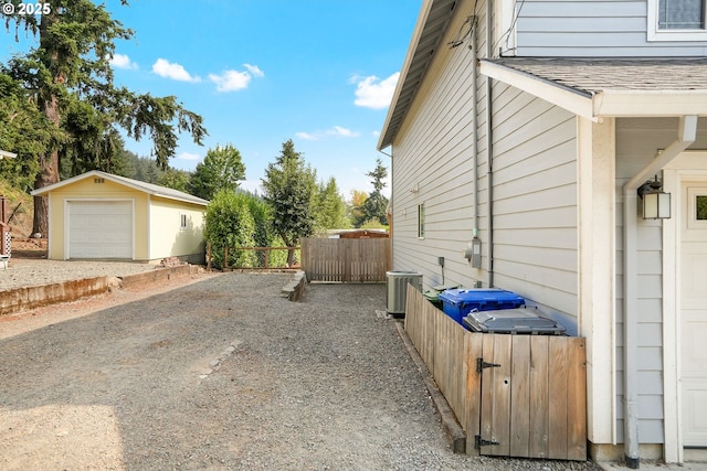 view of home's exterior featuring cooling unit, a garage, and an outdoor structure