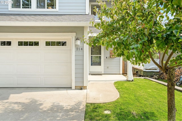 entrance to property featuring a lawn and a garage