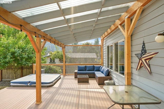 wooden terrace with an outdoor living space and a covered hot tub