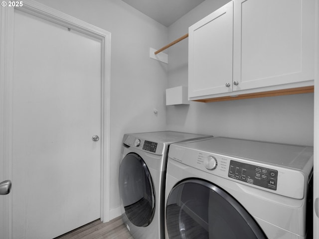 370 4th Pl, Manzanita, OR 97130 - washroom with cabinet space, washing machine and dryer, and light wood-style floors