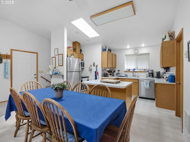 370 4th Pl, Manzanita, OR 97130 - kitchen with appliances with stainless steel finishes, light floors, light countertops, a sink, and brown cabinetry