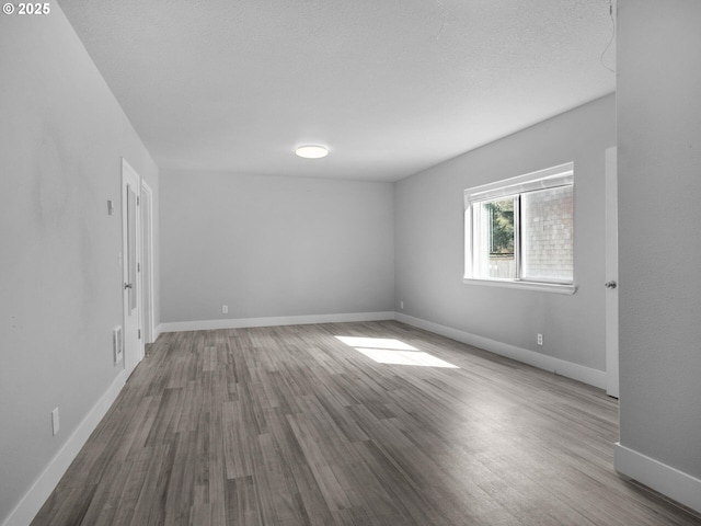 370 4th Pl, Manzanita, OR 97130 - spare room with wood finished floors, baseboards, and a textured ceiling