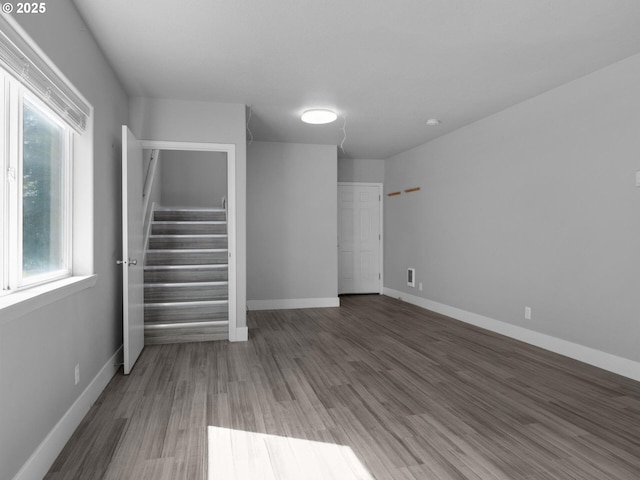370 4th Pl, Manzanita, OR 97130 - unfurnished living room with stairs, plenty of natural light, wood finished floors, and baseboards