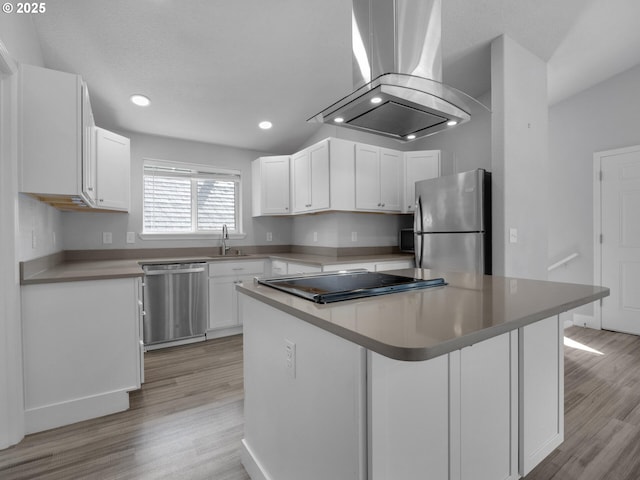 370 4th Pl, Manzanita, OR 97130 - kitchen featuring appliances with stainless steel finishes, island exhaust hood, light wood finished floors, white cabinetry, and recessed lighting