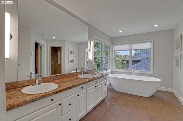 bathroom with a sink, a freestanding tub, a stall shower, and double vanity