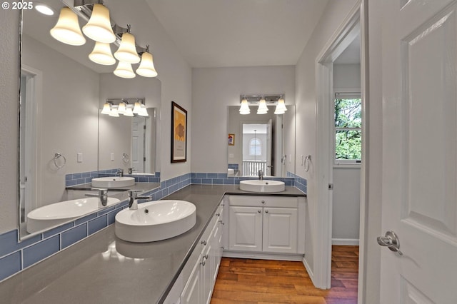 bathroom featuring a sink, double vanity, and wood finished floors
