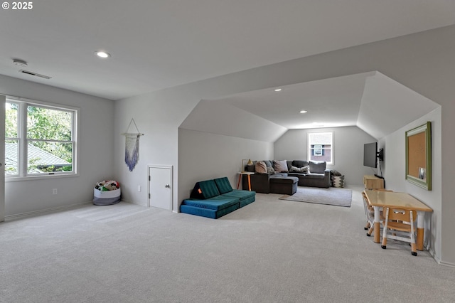 interior space featuring baseboards, carpet, vaulted ceiling, and visible vents