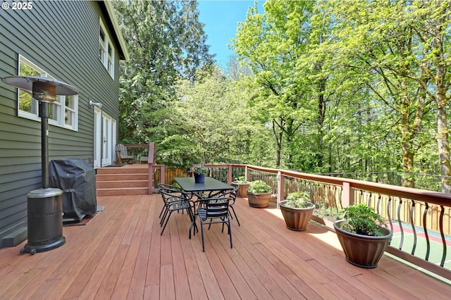 wooden terrace with outdoor dining space and a grill