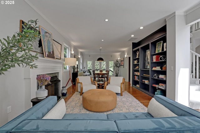 living area with recessed lighting, a fireplace with flush hearth, wood finished floors, and visible vents