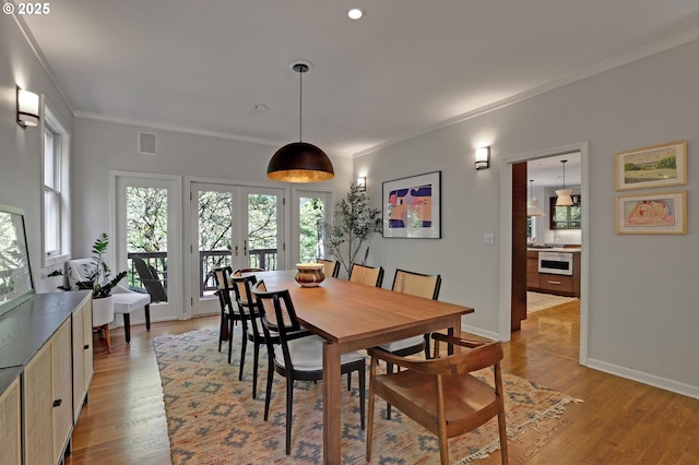dining space featuring light wood-style floors, recessed lighting, baseboards, visible vents, and ornamental molding