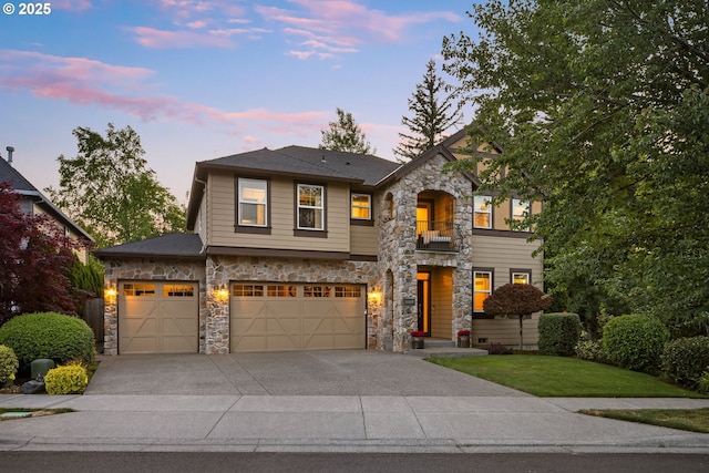18287 SW Florendo Ln, Beaverton, OR 97007 - view of front of house featuring stone siding, a balcony, concrete driveway, a yard, and a garage