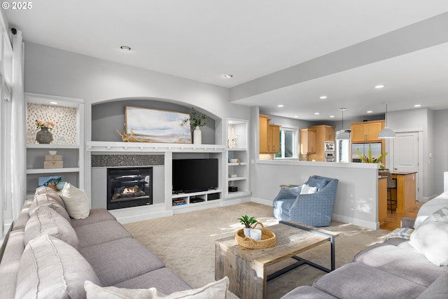 18287 SW Florendo Ln, Beaverton, OR 97007 - living area with light colored carpet, recessed lighting, a glass covered fireplace, and built in shelves