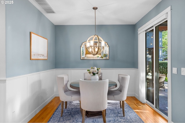 18287 SW Florendo Ln, Beaverton, OR 97007 - dining area with wood finished floors, wainscoting, and a chandelier