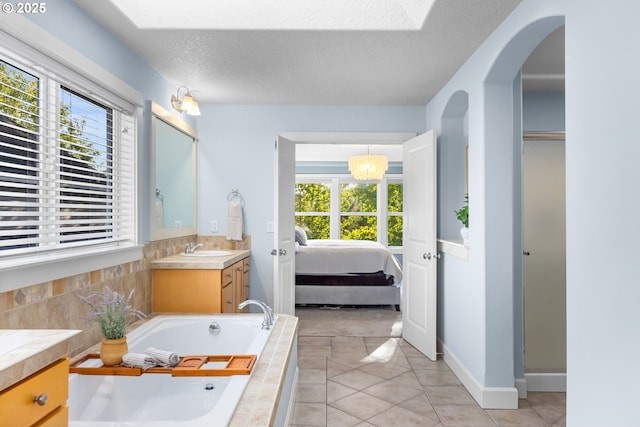 18287 SW Florendo Ln, Beaverton, OR 97007 - bathroom with vanity, a bath, connected bathroom, tile patterned flooring, and a textured ceiling