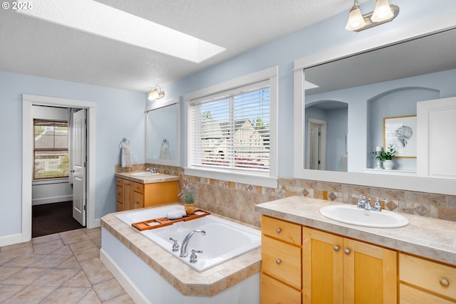 18287 SW Florendo Ln, Beaverton, OR 97007 - bathroom with two vanities, a skylight, a bath, and plenty of natural light
