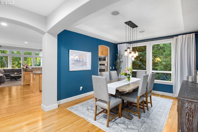 18287 SW Florendo Ln, Beaverton, OR 97007 - dining space featuring arched walkways, a tray ceiling, light wood-type flooring, recessed lighting, and a chandelier