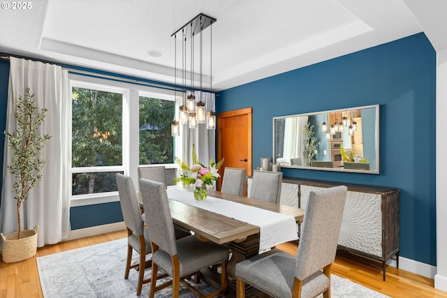 18287 SW Florendo Ln, Beaverton, OR 97007 - dining space with a tray ceiling, a chandelier, and wood finished floors